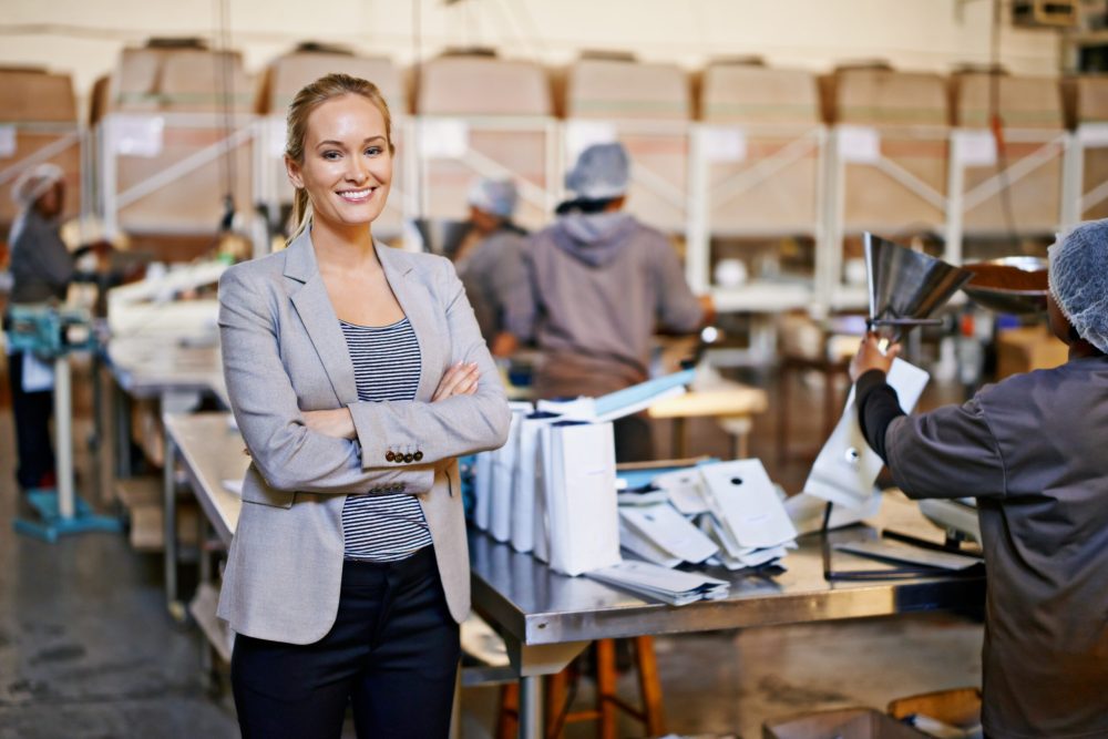 Woman, portrait and warehouse teamwork for packaging production with workers, distribution or shipping. Female person, face and factory manufacturing for parcel logistics, industrial or wholesale.