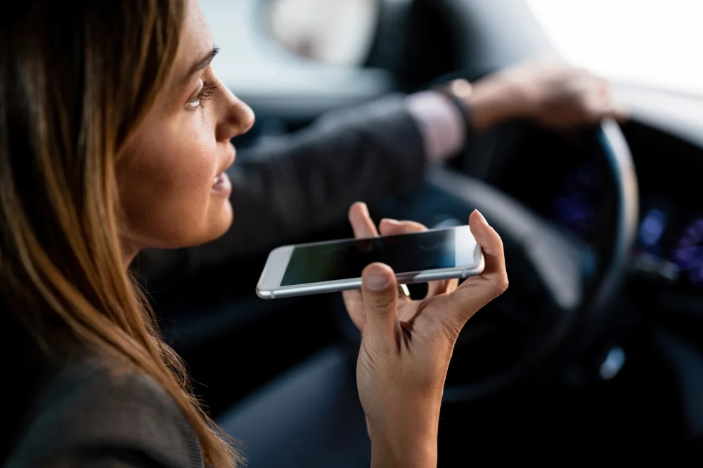 closeup-woman-using-mobile-phone-talking-speaker-while-driving-car